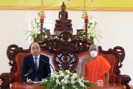 Chủ tịch nước Nguyễn Xuân Phúc nói chuyện với các vị chư tăng của Học viện Phật giáo Nam tông Khmer. (Ảnh: Thống Nhất/TTXVN)