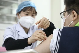 Nhân viên y tế tiêm vaccine phòng COVID-19 cho học sinh lớp 6 tại điểm tiêm chủng trường THCS Lê Ngọc Hân, quận Hai Bà Trưng, Hà Nội, vào sáng 17/4. (Ảnh: Minh Quyết/TTXVN)
