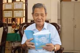 Ông Phạm Thanh Phong xem lại cuốn hồi ký khi vào Chiến khu Cách mạng. (Ảnh: Thanh Bình/TTXVN)