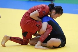 Vận động viên Phùng Thị Huệ (Việt Nam, đỏ) giành huy Vàng hạ knockout vận động viên Sakaew Tadaporn (Thái Lan, xanh) sau 33s. (Ảnh: Hoàng Hiếu/TTXVN)