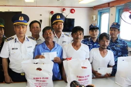 Đại diện Hải đoàn 32, Bộ Tư lệnh Vùng cảnh sát biển 3 trao quà hỗ trợ cho 4 ngư dân gặp nạn may mắn sống sót sau gần 10 ngày lênh đênh trên biển. (Ảnh: Phan Sáu/TTXVN)
