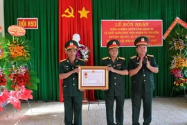 Thiếu tướng Hồ Minh Phương, Phó Chủ nhiệm Chính trị Quân khu 9 trao Huân chương Chiến công hạng Ba cho Tập thể Đội K93. (Ảnh: Thanh Sang/TTXVN)