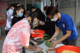 Các bạn sinh viên Lào, Trường Đại học Nha Trang gói bánh chưng theo hướng dẫn của thầy cô, bạn bè người Việt Nam. (Ảnh: Phan Sáu/TTXVN)