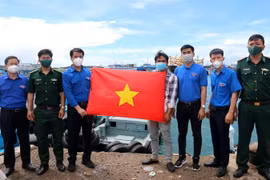 Trung ương Đoàn Thanh niên Cộng sản Hồ Chí Minh tặng cờ Tổ quốc cho ngư dân huyện đảo Phú Quý, tỉnh Bình Thuận. (Ảnh: Nguyễn Thanh/TTXVN)