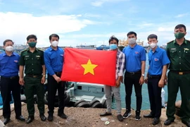 Trung ương Đoàn Thanh niên Cộng sản Hồ Chí Minh tặng cờ Tổ quốc cho ngư dân huyện đảo Phú Quý, tỉnh Bình Thuận. (Ảnh: Nguyễn Thanh/TTXVN)