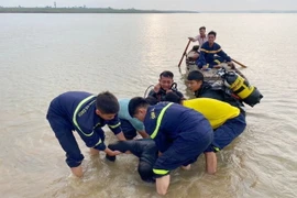 Đội Chữa cháy và cứu nạn, cứu hộ khu vực Trảng Bom thuộc Phòng Cảnh sát Phòng cháy, chữa cháy và cứu nạn, cứu hộ Công an tỉnh Đồng Nai, tổ chức tìm kiếm, trục vớt các nạn nhân. (Ảnh: Lê Xuân/TTXVN)
