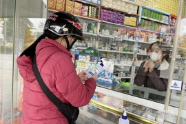 Người dân đến mua thuốc tại nhà thuốc. (Ảnh: Thanh Thủy/TTXVN)