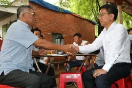 Chủ tịch UBND huyện Long Thành Lê Văn Tiếp (phải) và người dân bắt tay đã tìm được tiếng nói chung về giải phóng mặt bằng. (Ảnh: Công Phong/TTXVN)