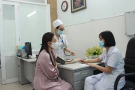 Bác sỹ của Phòng khám hậu COVID-19, Bệnh viện Đa khoa tỉnh Khánh Hòa thăm khám cho bệnh nhân đến khám do nghi ngờ mắc các triệu chứng hậu COVID-19. (Ảnh: Phan Sáu/TTXVN)