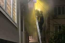 Lực lượng Cảnh sát phòng chống chữa cháy và cứu hộ cứu nạn Công an quận Hai Bà Trưng triển khai cứu người mắc kẹt trong đám cháy. (Ảnh: TTXVN phát)