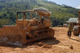 Chủ đầu tư đưa phương tiện cơ giới thi công đường Trường Sơn Đông tại rừng đặc dụng. (Ảnh: TTXVN phát)