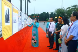 Các đại biểu xem các bức ảnh tại Triển lãm “Đẩy mạnh học tập và làm theo tư tưởng, đạo đức, phong cách Hồ Chí Minh.” (Ảnh: Tá Chuyên/TTXVN)