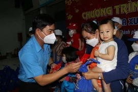 Phó Chủ tịch Liên đoàn Lao động TP Hồ Chí Minh Phạm Chí Tâm thăm hỏi, chúc Tết tặng quà cho công nhân lao động về quê đón Tết trên "Chuyến tàu mùa Xuân." (Ảnh: Thanh Vũ/TTXVN)