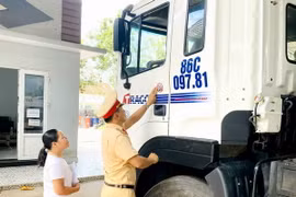 Lực lượng cảnh sát giao thông tiến hành dán Logo decal với nội dung “Đã uống rượu bia-Không lái xe” lên các phương tiện vận tải là thành viên của Hợp tác xã vận tải ôtô Phan Thiết. (Ảnh: Nguyễn Thanh/TTXVN)