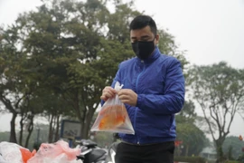 [Photo] Người dân Thủ đô thả cá chép tiễn ông Táo về trời 