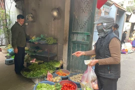 Người lao động thu nhập thấp xoay sở sinh hoạt khi vật giá hàng hoá, thực phẩm tăng cao. (Ảnh: PV/Vietnam+)