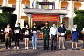 Lãnh đạo Ủy ban Nhân dân tỉnh Sóc Trăng và Bộ chỉ huy Quân sự tỉnh Sóc Trăng trao chứng nhận hoàn thành cách ly cho các công dân. (Ảnh: Trung Hiếu/TTXVN)