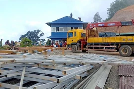 Lực lượng chức năng tháo dỡ công trình xây dựng trái phép trên đèo Đại Ninh. (Ảnh: Nguyễn Thanh/TTXVN)
