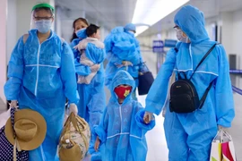 Toàn bộ hành khách, phi hành đoàn, nhân viên mặt đất đều được mặc đồ bảo hộ đảm bảo an toàn. (Ảnh: Đinh Hằng/TTXVN)