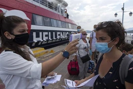 Kiểm tra thân nhiệt du khách. (Ảnh: THX/TTXVN)