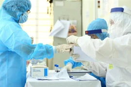 Nhân viên y tế xét nghiệm nhanh cho người về từ Đà Nẵng. (Ảnh: Minh Quyết/TTXVN)