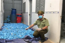 Hàng nghìn găng tay y tế được tái chế chuẩn bị bán ra thị trường. (Ảnh: TTXVN)