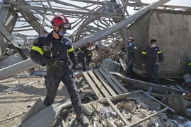 Nhân viên cứu hộ đến từ Pháp tìm kiếm nạn nhân dưới đống đổ nát sau vụ nổ ở Beirut, Liban. (Ảnh: AFP/TTXVN)