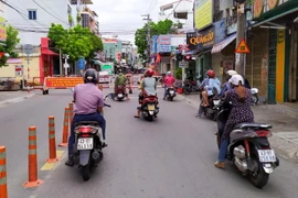 Người dân Đà Nẵng tuân thủ cách ly xã hội dừng xe giãn cách khi tham gia giao thông. (Ảnh: Trần Lê Lâm/TTXVN)