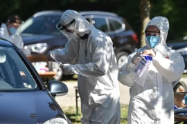 Nhân viên y tế lấy mẫu dịch xét nghiệm COVID-19 cho người dân tại Mamming, miền Nam Đức. (Ảnh: AFP/TTXVN)