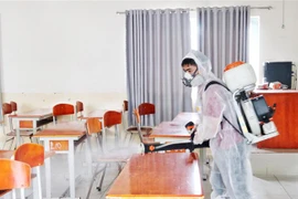 Các phòng dự bị cho kỳ thi tốt nghiệp Trung học phổ thông năm 2020 được nhân viên phun thuốc khử trùng đảm. (Ảnh: Thu Hương/TTXVN)