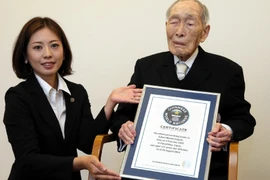 Cụ Sakari Momoi (phải) nhận giấy chứng nhận của Guinness tại Tokyo ngày 20/8/2014. (Nguồn: AFP/TTXVN)