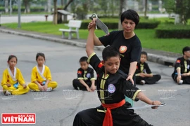 Nữ võ sư Thanh Tâm hướng dẫn võ sinh luyện tập bài song đao. (Ảnh: Trần Thanh Giang)