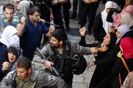 Cảnh sát Israel bắt giữ một phụ nữ Palestin trong cuộc xung đột giữa cảnh sát và người biểu tình. (Nguồn: AFP/TTXVN)