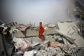 Nhân viên Chữ thập đỏ Syria tìm kiếm người mất tích trong đống đổ nát sau vụ không kích ở Douma ngày 22/8. (Nguồn: AFP/TTXVN)