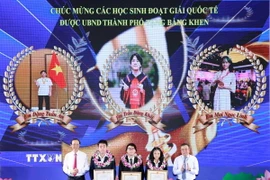 Chủ tịch UBND thành phố Hà Nội tặng bằng khen cho các học sinh xuất sắc, có nhiều thành tích. (Ảnh: Thanh Tùng/TTXVN)