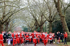 Người dân tham gia cuộc thi chạy Ông già Noel ở London, Anh. (Ảnh: THX/TTXVN)