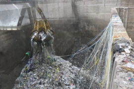 Vận chuyển rác vào lò đốt. (Ảnh: Đỗ Huyền/TTXVN)