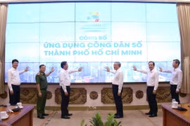 Phó Thủ tướng Thường trực Chính phủ Nguyễn Hòa Bình và các đại biểu thực hiện nghi thức ra mắt ứng dụng “Công dân số Thành phố Hồ Chí Minh.” (Ảnh: Tiến Lực/TTXVN)