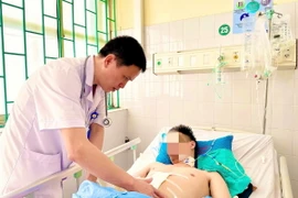 Bác sỹ Lê Ngọc Sơn, Phó Khoa Cấp cứu-Hồi sức tích cực 2, thăm khám cho bệnh nhân trước khi xuất viện. (Ảnh: TTXVN phát)