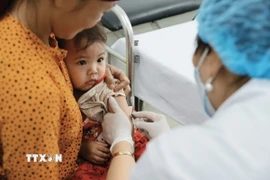 Nhân viên y tế tiêm vaccine cho trẻ tại trạm y tế xã. (Ảnh: Minh Quyết/TTXVN)