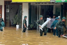 Cán bộ, chiến sỹ Ban chỉ huy Quân sự huyện Na Hang, tỉnh Tuyên Quang hỗ trợ người dân chuyển đồ đạc. (Ảnh: Hoàng Hải/TTXVN)