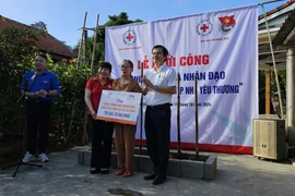 Trao hỗ trợ xây nhà cho bà Phạm Thị Gái. (Ảnh: Mai Trang/TTXVN)