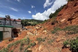 Đất đá sạt lở ngổn ngang ngay phía sau nhà các hộ dân thuộc Tổ 24, thôn Quảng Hiệp, xã Hiệp Thạnh, huyện Đức Trọng. (Ảnh: Nguyễn Dũng/TTXVN)