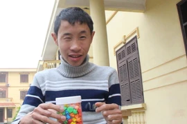 Em Đoàn Trung Đức vẫn luôn cầm trong tay hộp sao với khát khao được về quê ăn Tết cùng gia đình. (Ảnh: Văn Quế/Vietnam+)