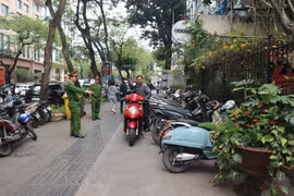 Công an phường Phan Chu Trinh (Hoàn Kiếm) nhắc nhở chủ cơ sở kinh doanh không được đỗ xe trên vỉa hè đường Lý Thường Kiệt. (Ảnh: Mạnh Khánh/TTXVN)