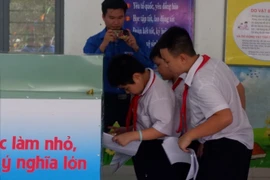 Các bạn nhỏ thực hiện phân loại rác. (Ảnh: Văn Dũng/TTXVN)