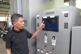 Ông Trịnh Đình Năng bên hệ thống điều khiển của lò đốt rác thải y tế. (Ảnh: Nguyễn Trình/Vietnam+)