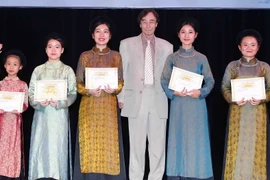 Giáo sư Odon Vallet trao Giấy chứng nhận và học bổng Vallet cho các em học sinh có thành tích xuất sắc trong học tập. (Ảnh: Quý Trung/TTXVN)