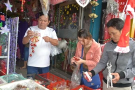 Khách chọn mua đồ trang trí Giáng sinh. (Ảnh: Đinh Văn Nhiều/TTXVN)