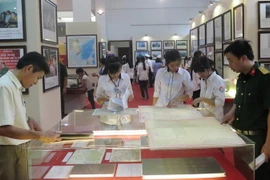 Người dân nghiên cứu các tài liệu, bản đồ - là chứng cứ lịch sử và cơ sở pháp lý về chủ quyền của Việt Nam đối với Hoàng Sa và Trường Sa tại Nam Định. (Ảnh: Văn Đạt/TTXVN)